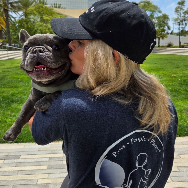 A supporter wearing the Larry Blue Foundation tee on a walk with her French bulldog
