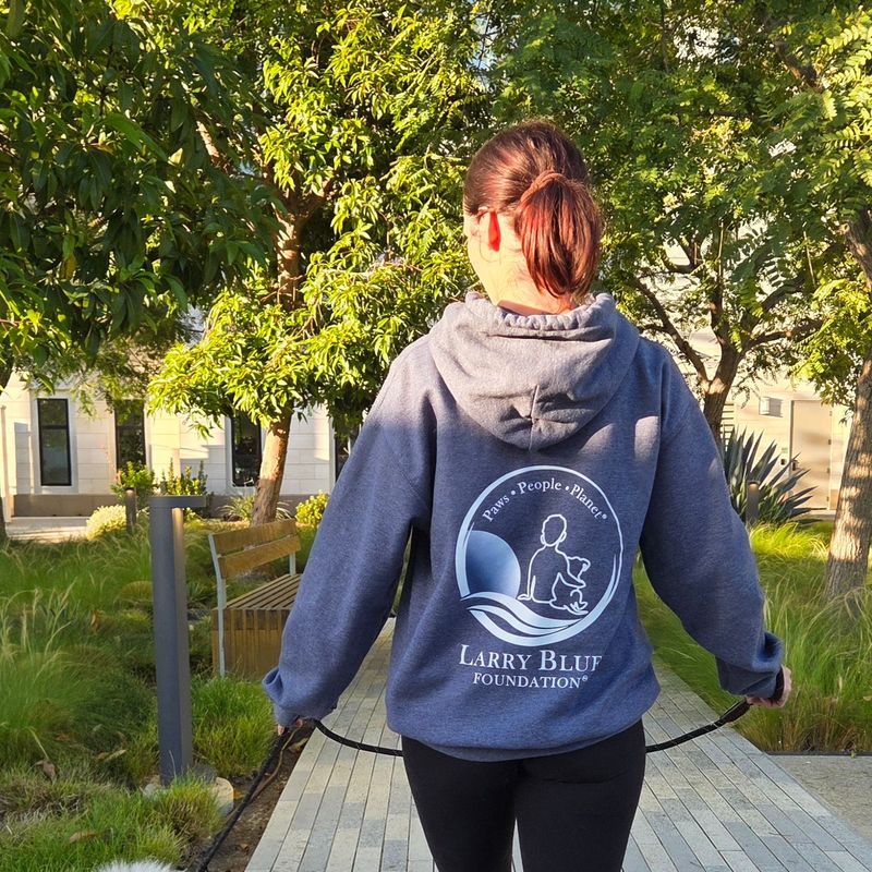 A supporter wearing the Larry Blue Foundation hoodie on a walk with her dog